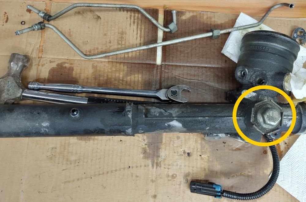 A c5 Corvette steering rack with the tension nut highlighted in hyellow