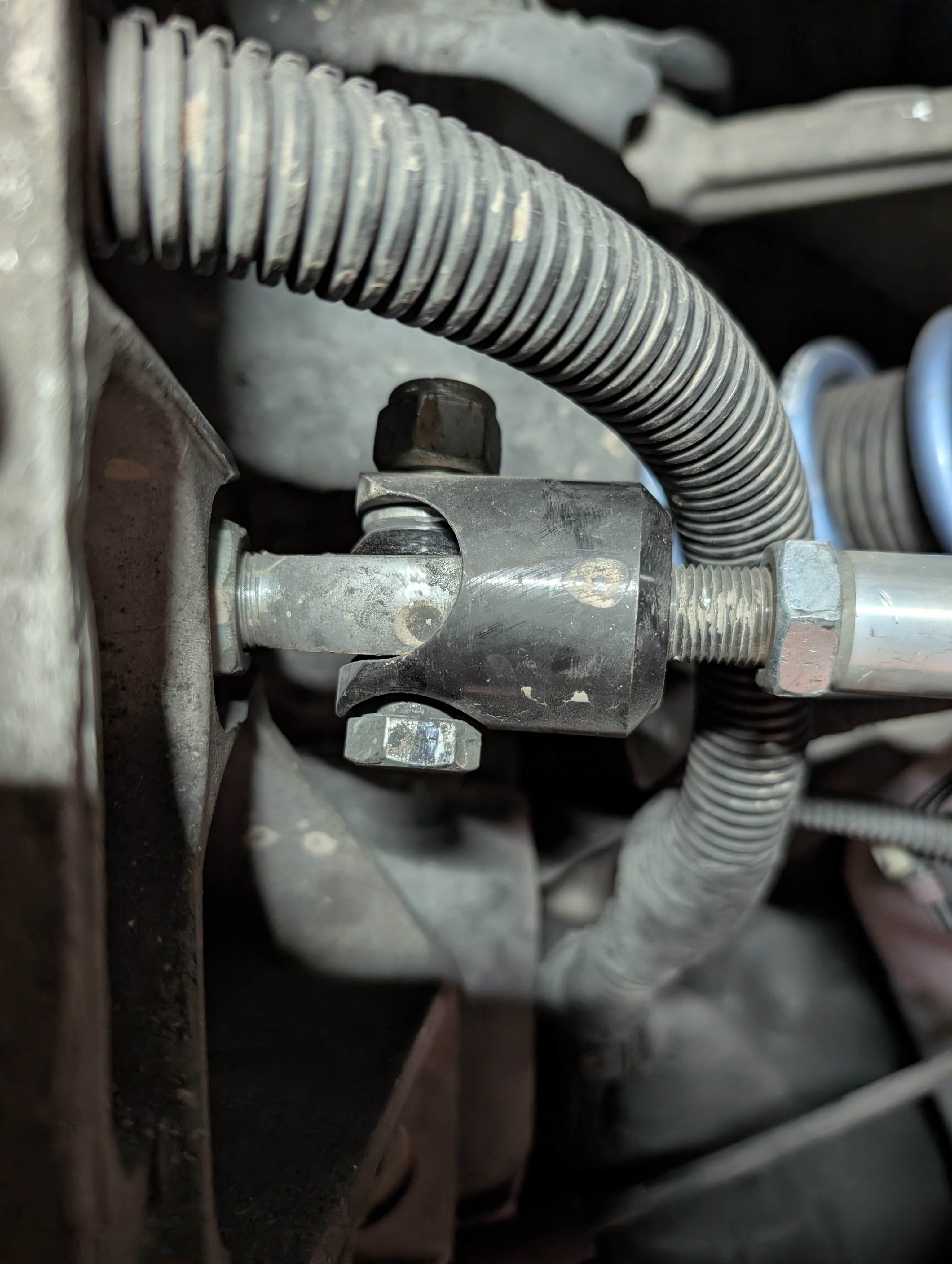 A rear aftermarket inner tie rod mount on the Dead to Shred Corvette, where a bolt and nylock nut has been run through the mount instead of the correct torx bolt.