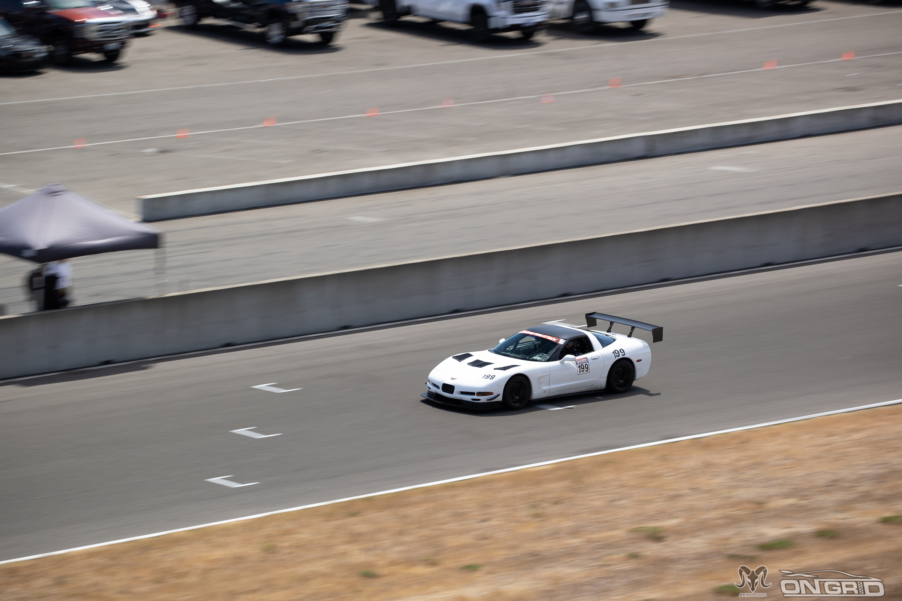Shred Jesse's white 1999 C5 Corvette going down the front straight of the ridge with a big wing on the back of it.