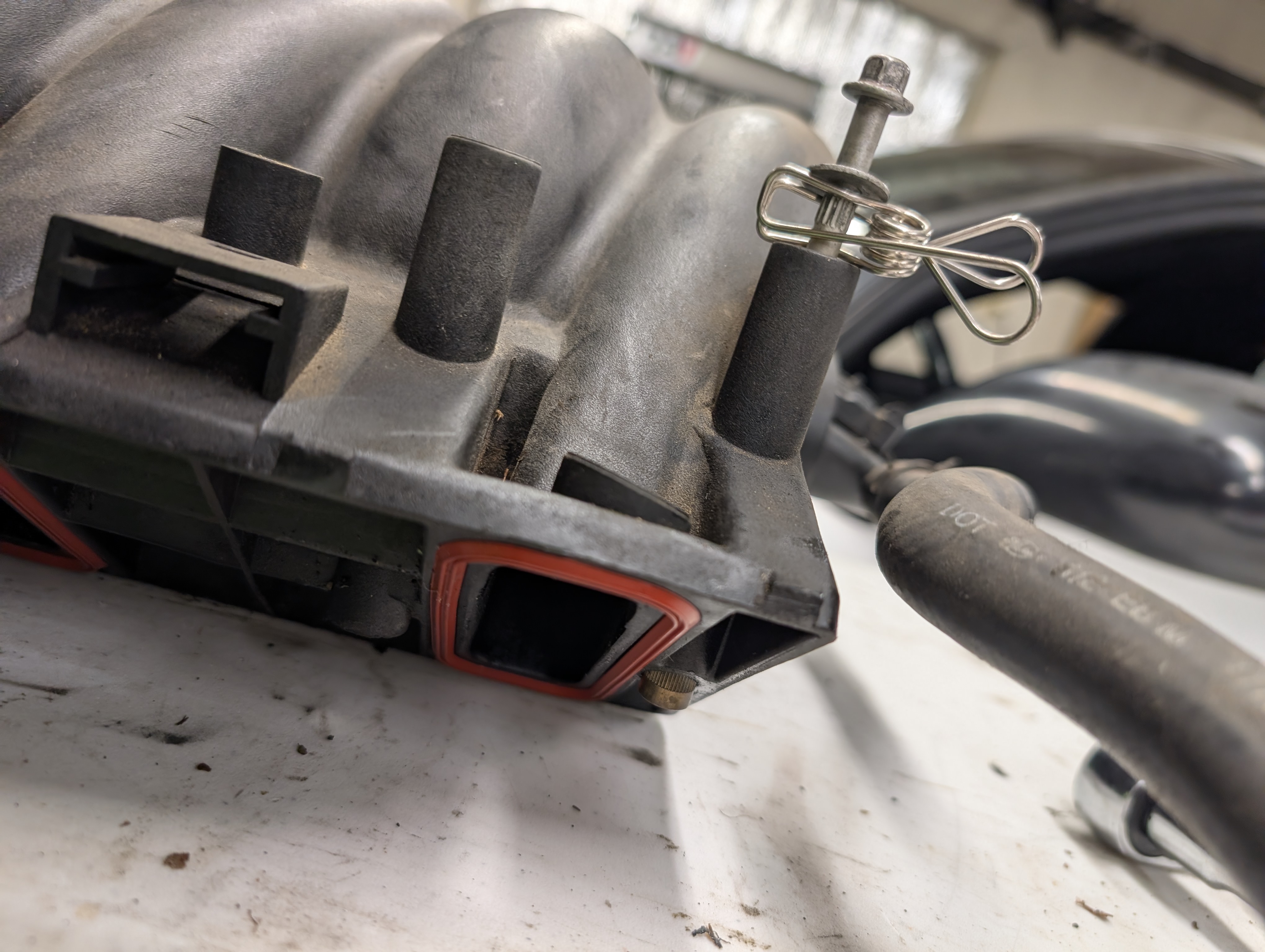 A clothes pin hold up the rearmost bolt of the C5 LS1 intake manifold. This makes slipping the intake manifold under the engine cowl a one man job on a C5 Corvette.