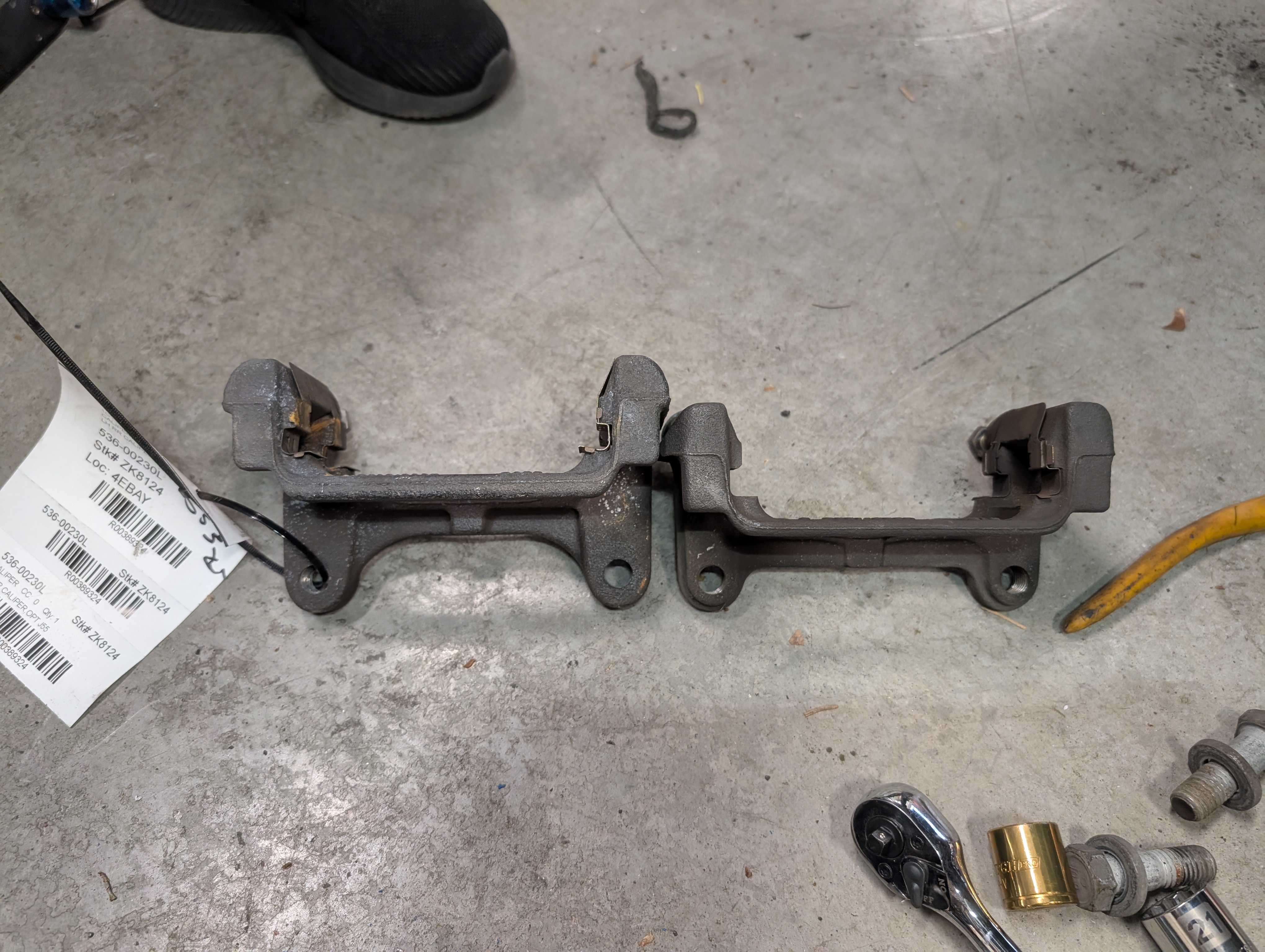 C6 J55 rear brake brackets on he left, with C5 oem rear brake brackets on the left, exaemplifying the additional diameter of the C6 J55 rear brake upgrade.