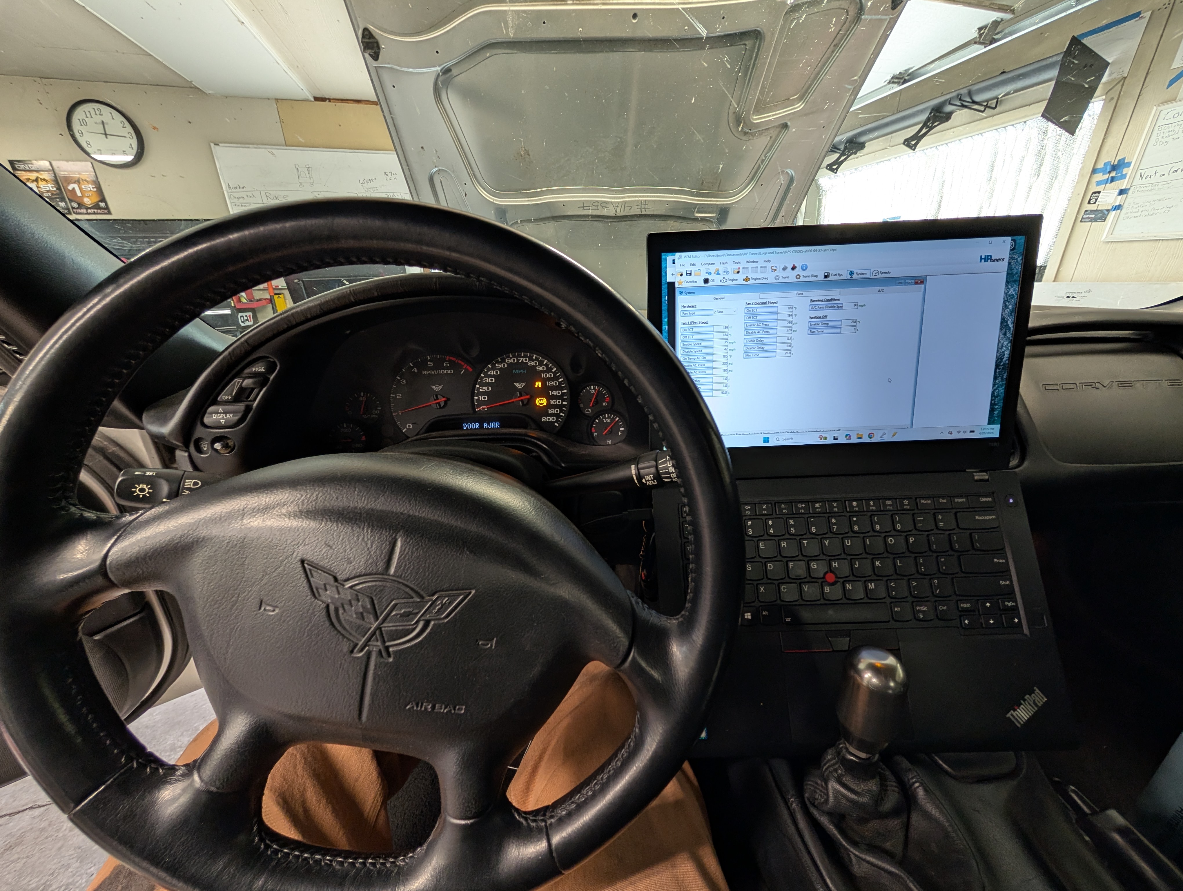 The inside of a C5 Corvette as seen from the drivers seat. There is a laptop with HP tuners on it in front of the shifter.