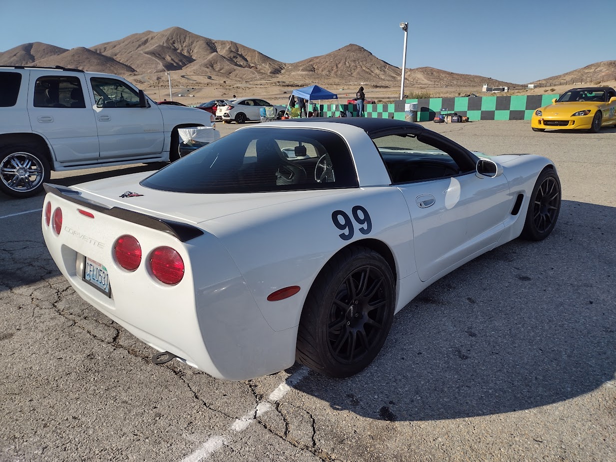 A white 1999 C5 Corvette pictured with a black duckbill spoiler on the rear