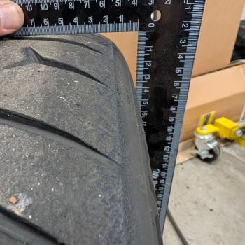 A measuring square pressed up against the outside of a Continental Extreme Contact Force tire to demonstrate side profile.