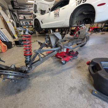 The rear subframe of a C5 Corvette removed from the car and sitting on a transmission dolly