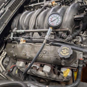 A 2001 C5 Corvette LS engine with a compression tester on it showing 190psi